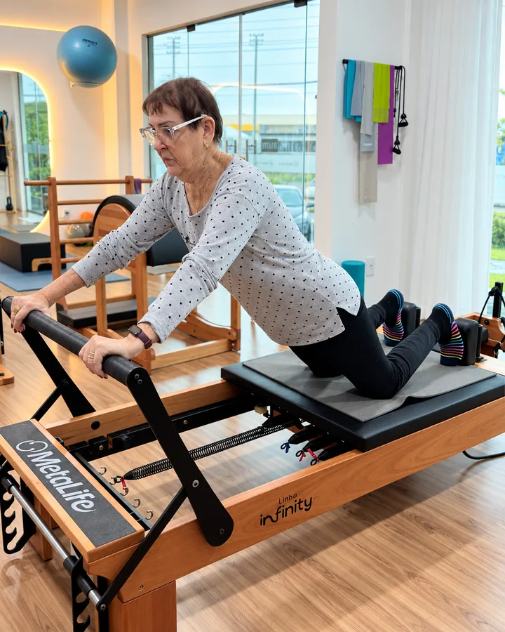 Aluna madura em exercício no reformer do Studio Vitali