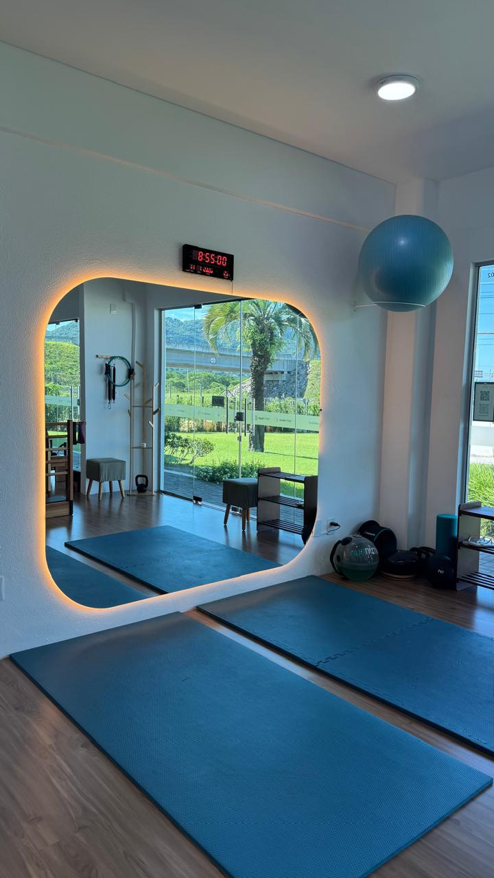 Espaço de exercícios com espelho LED e colchonetes no Studio Vitali